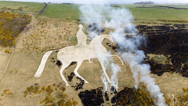 An aerial view of a controlled burn being carried out at the White Horse Hill chalk figure, Osmington, to maintain the Dorset landmark's traditional shape, on March 26, 2025 in Weymouth, United Kingdom. (Photo by Finnbarr Webster/Getty Images)