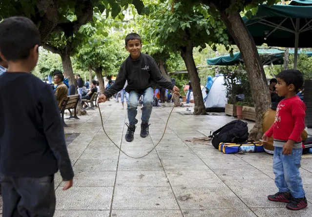 An Afghan refugee boy jumps rope in Victoria Square, where hundreds of migrants and refugees sleep rough, in central Athens, Greece, September 22, 2015. (Photo by Paul Hanna/Reuters)