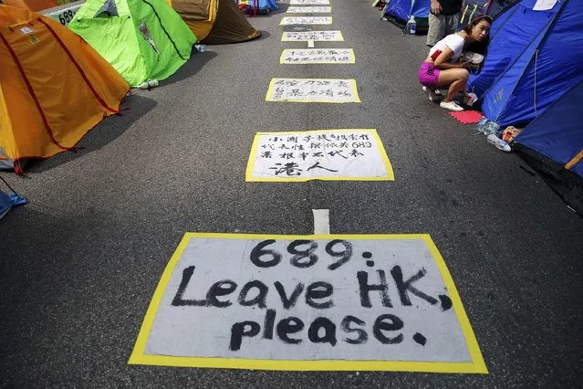 A pro-democracy protester gets out of her tent set-up on the road decorated with messages in the part of Hong Kong's financial central district protesters are occupying November 2, 2014. “689”  is a nickname for Hong Kong Chief Executive Leung Chun-ying, in reference to the number of votes he gained out of 1200 during the 2012 Hong Kong Chief Executive Election. (Photo by Damir Sagolj/Reuters)