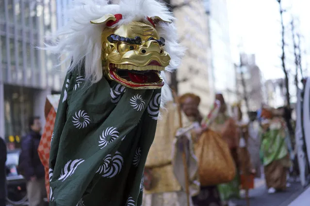 A lion dancer, known as Shishimai, performs ritual dance during First Konpira Festival at Kotohira-gu shrine in Tokyo Wednesday, January 10, 2018. People believe Shishimai lion dance, held on New Year's Day season, brings good fortune and dispels evils. (Photo by Eugene Hoshiko/AP Photo)