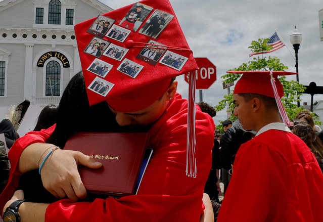 A classmate of high school student Marcelo Gomes da Silva, who was reportedly detained by Immigration and Customs Enforcement (ICE) agents, is embraced while wearing a graduation cap featuring photographs of da Silva during a rally in support of da Silva in Milford, Massachusetts on June 1, 2025. (Photo by Brian Snyder/Reuters)