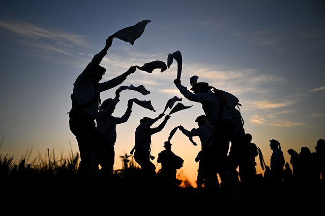 The Wessex Morris Men welcome in May Day dancing at sunrise above the Cerne Abbas Giant, on May 01, 2025 in Cerne Abbas, United Kingdom. The Wessex Morris dancers greet the sunrise on 1st May on the Trendle, a square earth-banked enclosure above the Cerne Abbas Giant's head, where a maypole once stood. This is followed by a procession to the square where further dancing takes place and a short celebration of the season at the Silver Well in the Celtic Christian tradition. (Photo by Finnbarr Webster/Getty Images)