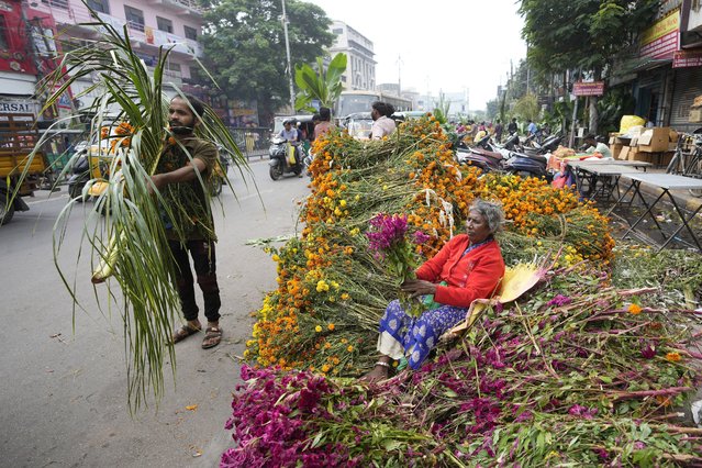 A women vendor arranges flowers while waiting for customers, during Diwali, the festival of lights, in Hyderabad, India, Thursday, October 31, 2024. (Photo by Mahesh Kumar A./AP Photo)