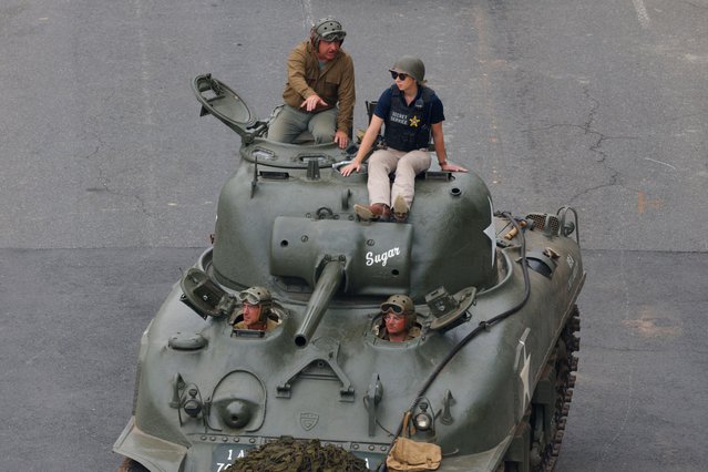 A member of the secret service rides on top of an armored vehicle during the parade in Washington on June 14, 2025. (Photo by Brian Snyder/Reuters)