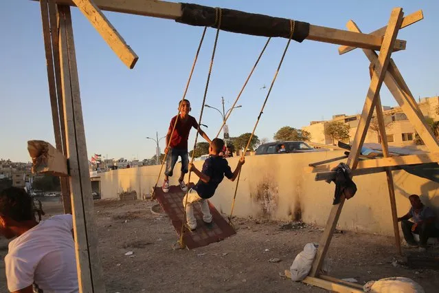 Jordanian kids playing on a swing during the Eid celebration in Amman, Jordan, 12 September 2016. Eid al-Adha is the holiest of the two Muslims holidays celebrated each year, it marks the yearly Muslim pilgrimage (Hajj) to visit Mecca, the holiest place in Islam. Muslims slaughter a sacrificial animal and split the meat into three parts, one for the family, one for friends and relatives, and one for the poor and needy. (Photo by Jamal Nasrallah/EPA)