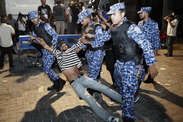 Maldivian police officers detain an opposition protestor demanding the release of political prisoners during a protest in Male, Maldives, Friday, February 2, 2018. Supporters of political parties that oppose the Maldives government have clashed with police on the streets of the capital after the country's supreme court ordered the release of imprisoned politicians. (Photo by Mohamed Sharuhaan/AP Photo)