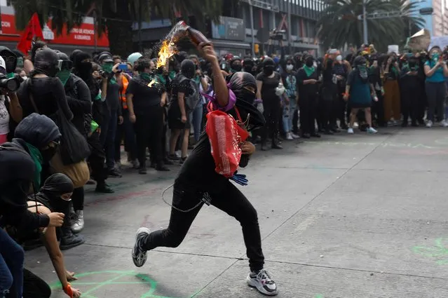 Member of a feminist collective throws a molotov cocktail during a march to mark the International Safe Abortion Day in Mexico City, Mexico on September 28, 2020. (Photo by Carlos Jasso/Reuters)