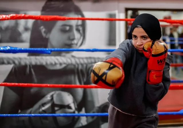 A Palestinian girl, warms up during training inside the first women boxing center in Gaza City on January 17, 2023. (Photo by Mohammed Salem/Reuters)