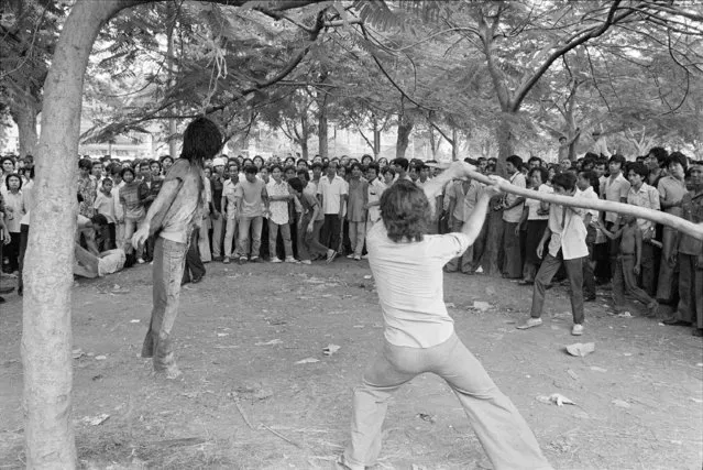 In this October 6, 1976 file photo a member of a Thai political faction strikes at the lifeless body of a hanged student outside Thammasat University in Bangkok Oct. 6, 1976. (Photo by Neal Ulevich/AP Photo)