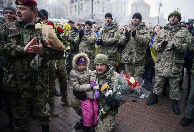 A serviceman of “Kiev 12” military defence battalion embraces his daughter as he attends a welcoming ceremony in central Ukrainian capital Kiev December 6, 2014. (Photo by Gleb Garanich/Reuters)