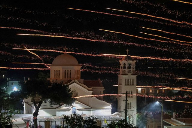 Handmade rockets fly over Saint Mark church during Greek Orthodox Easter celebrations in the village of Vrontados, on the island of Chios, Greece, on May 4, 2024. During the Orthodox Easter midnight mass service residents of two “rival” churches, Panagia Erithiani and Saint Mark, fire handmade firework-like rockets at each other's steeples, unleashing thousands of rockets into the night sky, in a tradition going back generations. (Photo by Konstantinos Anagnostou/Reuters)
