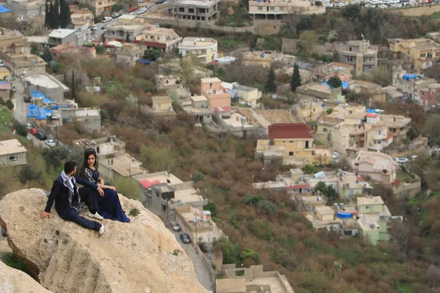 A Kurdish man and woman sit on a mountain as they celebrate Newroz Day in Akra, Iraq on March 20, 2018. (Photo by Ari Jalal/Reuters)