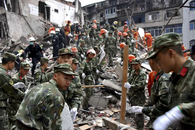 Rescuers clear the debris to search for victims on the site of collapsed residential buildings in Wenzhou city in east China's Zhejiang province, Monday, October 10, 2016. More than dozen people were believed to be buried after four residential houses collapsed on Monday early morning. (Photo by AP Photo)