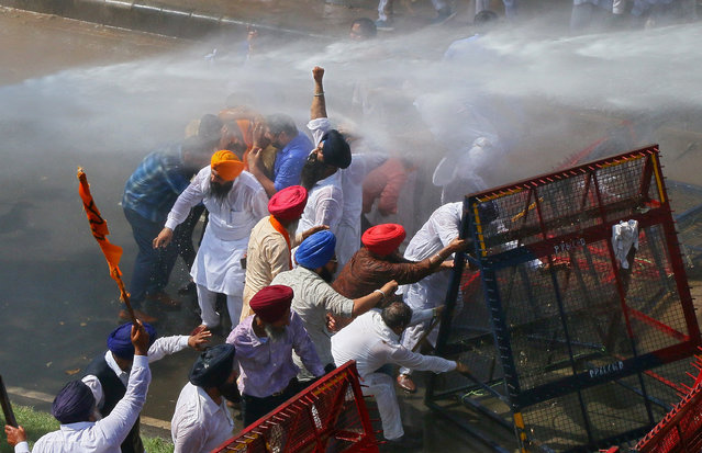 Demonstrators are hit by police water cannon during a protest, organised by Punjab's main opposition party Shiromani Akali Dal (SAD), demanding debt waiver of farmers in Chandigarh, India on March 20, 2018. (Photo by Ajay Verma/Reuters)