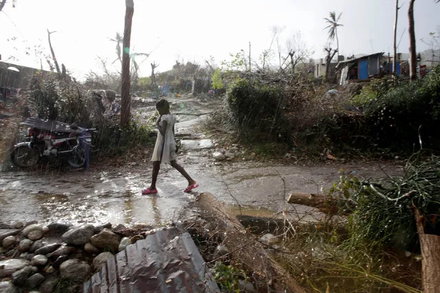 A girl walks under the rain in an area destroyed by Hurricane Matthew in Les Anglais, Haiti, October 13, 2016. (Photo by Andres Martinez Casares/Reuters)
