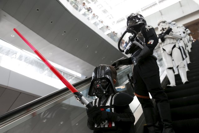 Wesley Poh, a 5-year-old child dressed as Darth Vader, who came with his parents to visit the "Star Wars" exhibits, leads a group of Stormtrooper actors as they march around Singapore's Changi Airport November 12, 2015. (Photo by Edgar Su/Reuters)