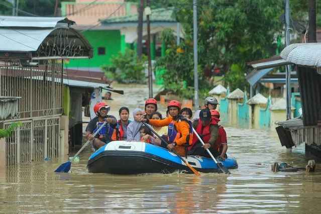 Rescuers evacuate residents amid flooding caused by overnight heavy rains in Medan, North Sumatra, on December 4, 2020. (Photo by Rahmad Suryadi/AFP Photo)