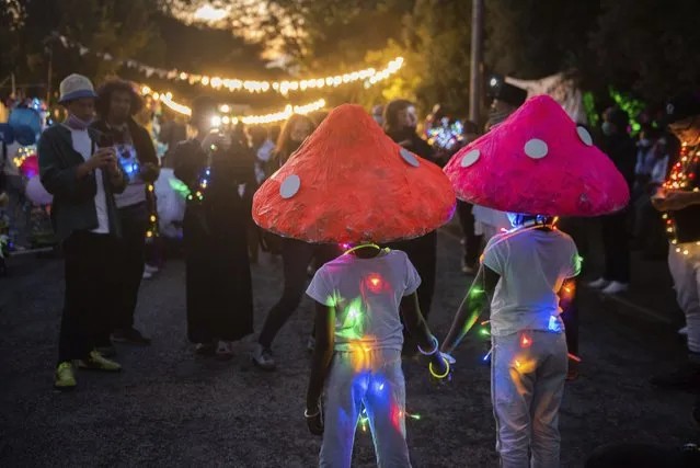 Children, with mushroom headdresses, pose for photos as they parade through the streets of Brixton, in Johannesburg during the Light Festival, Sunday, February 6, 2022. (Photo by Alet Pretorius/AP Photo)