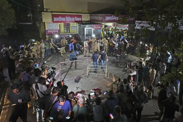 Police and media surround the area where  Gangster-turned-politician Atiq Ahmad and his brother Ashraf were shot in front of the Motilal Nehru medical college in, Prayagraj, India, Saturday, April 15, 2023. Jailed gangster-turned-politician Atiq Ahmad and his brother Ashraf were shot dead by unidentified assailants while they were being escorted by police to a medical college here on Saturday night, according to the Indian news agency Press Trust of India. (Photo by Rajesh Kumar Singh/AP Photo)