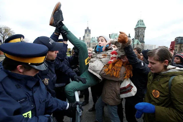 A protestor struggles to cross a police barricade during a demonstration against the proposed Kinder Morgan pipeline on Parliament Hill in Ottawa, Ontario, Canada, October 24, 2016. (Photo by Chris Wattie/Reuters)