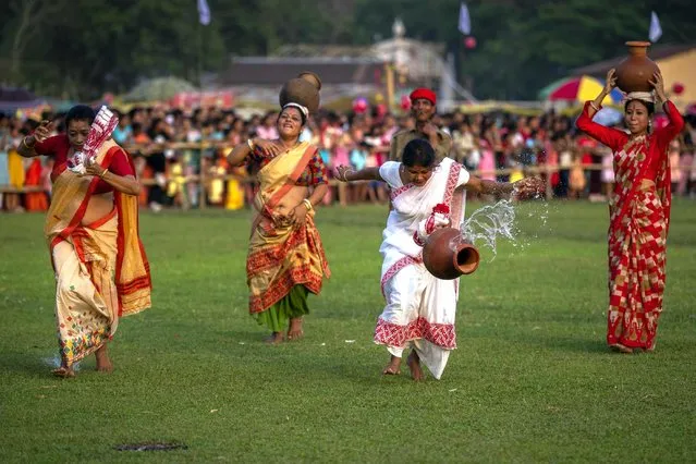 Indian women with earthen pots filled with water participate in a traditional game during Suwori festival in Boko, west of Guwahati, India, Thursday, April 20, 2023. Traditional tug of war and dances mark this festival which coincides with the Assamese Rongali Bihu, or the harvest festival of the northeastern Indian state of Assam. (Photo by Anupam Nath/AP Photo)