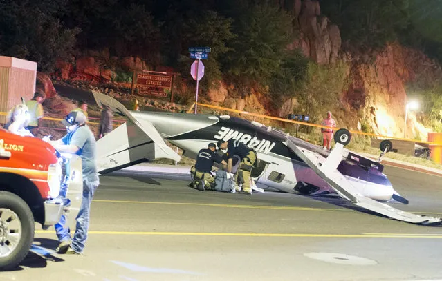 This Tuesday, May 29, 2018 photo shows firefighters responding to a Piper Malibu, 6-seater aircraft, that crash landed on a street in Prescott, Ariz. Authorities in Prescott, Arizona, say a single-engine plane reportedly running low on fuel crashed while making an emergency landing on a street, injuring the three people involved. (Photo by Les Stukenberg/The Daily Courier via AP Photo)