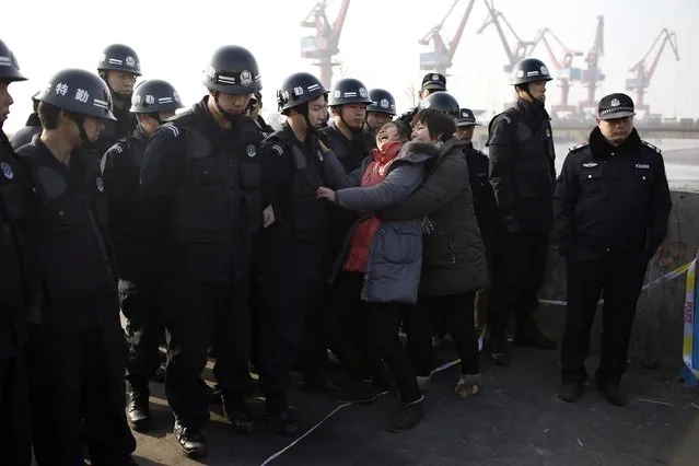 Relatives of a person missing after a tug boat sank, scuffle with police officers as they mourn on the bank of the Yangtze River, near Jingjiang, Jiangsu province January 17, 2015. (Photo by Aly Song/Reuters)