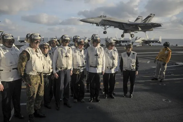 Ukrainian Prime Minister Arseny Yatseniuk (4th L) and Defence Minister Stepan Poltorak (3rd L) stand on the flight deck of the nuclear-powered aircraft carrier USS Harry S. Truman at the  at an undisclosed position in the Mediterranean Sea, December 3, 2015. (Photo by Andrew Kravchenko/Reuters)