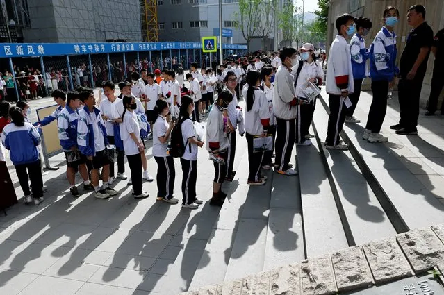 Students line up to enter a school on the first day of China's national college entrance examination, known as the gaokao, in Beijing on June 7, 2023. (Photo by Wang Zhao/AFP Photo)