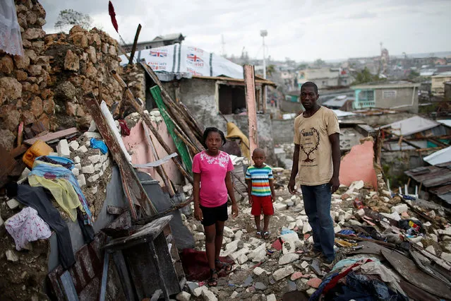 Prenille Nord, 42, poses for a photograph with his children Darline and Kervins among the debris of their destroyed house after Hurricane Matthew hit Jeremie, Haiti, October 17, 2016. “My house is completely destroyed, I have nothing left. Now we are homeless and I'm currently living in a shelter with my family but that makes no sense to me. I'm scared of the cholera. People around us are becoming sick, I really need help, so far we have not received any aid”, said Nord. (Photo by Carlos Garcia Rawlins/Reuters)