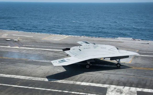 An X-47B Unmanned Combat Air System (UCAS) makes the very first carrier landing aboard the USS George H.W. Bush while afloat in the Atlantic Ocean off the coast from Norfolk, Virginia, on July 11, 2013. (Photo by Jim Watson/Getty Images)