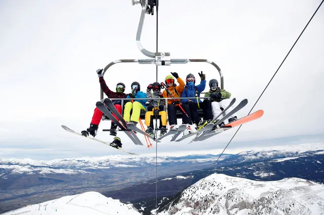 Skiers and snowboarders gesture from a chairlift as La Masella ski resort re-opens observing nationwide coronavirus disease (COVID-19) restrictions, in Masella, Spain, December 14, 2020. (Photo by Albert Gea/Reuters)