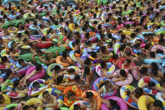 Visitors crowd an artificial wave pool at a tourist resort to escape the summer heat in Daying county of Suining, Sichuan province, July 27, 2013. (Photo by Reuters/China Daily)