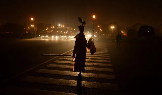 An Indian woman crosses the road in New Delhi on January 20, 2015. India is part of a global trend that is advancing towards an increasing urbanisation, with more than half of the world's population living in towns and cities. (Photo by Chandan Khanna/AFP Photo)