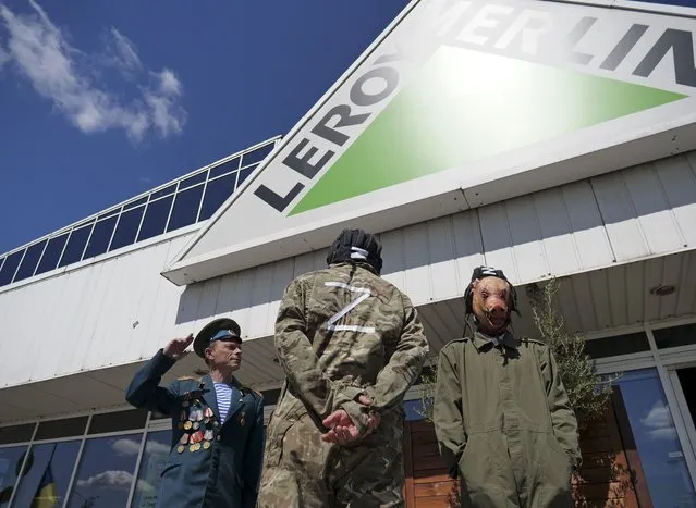 Activists, including Arkadiusz Szczurek, left, take part in a protest outside an outlet of French home improvement retailer Leroy Merlin in Warsaw, Poland, on Saturday May 7, 2022. In the weeks after Russia invaded Ukraine, a protest movement was born in Poland urging people to boycott companies that have chosen to keep operating in Russia. (Photo by Pawel Kuczynski/AP Photo)