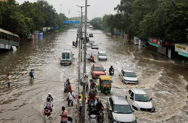 Traffic moves through a flooded road, after a rise in the waters of river Yamuna due to heavy monsoon rains, in New Delhi, India on July 14, 2023. (Photo by Adnan Abidi/Reuters)