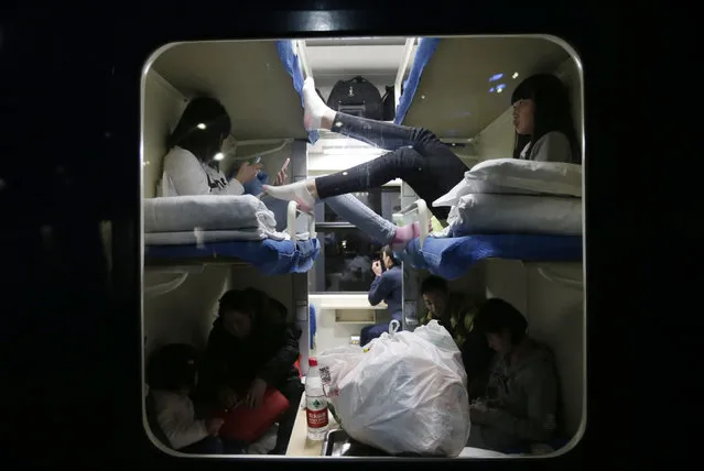 Passengers are seen through the window of a train at Beijing Railway Station, February 5, 2015. Chinese Ministry of Transport said a total of 2.807 billion trips are expected to be made during the 40-day Spring Festival travel rush, which will begin on February 4 and last until March 16, Xinhua News Agency reported. (Photo by Jason Lee/Reuters)