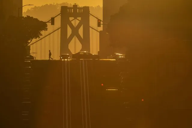 The bay bridge is seen during sunrise along California Street in San Francisco, California, U.S., April 12, 2023. (Photo by Carlos Barria/Reuters)