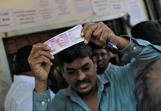 A man holds 2000 Indian rupees notes as he gets out of a bank in Mumbai, India, November 24, 2016. (Photo by Danish Siddiqui/Reuters)