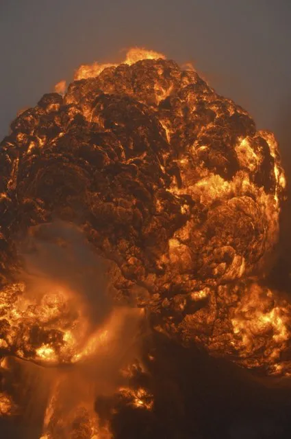 An explosion erupts from a CSX Corp train derailment in Mount Carbon West Virginia pictured across the Kanawha River in Boomer, West Virginia February 16, 2015. A CSX Corp train hauling North Dakota crude derailed in West Virginia on Monday, setting a number of cars ablaze, destroying a house and forcing the evacuation of two towns in the second significant oil-train incident in three days. (Photo by Steve Keenan/Reuters)
