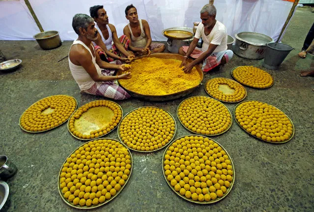 Devotees prepare “Laddu”, a ball-shaped sweet to offer in front of an idol of Hindu god Ganesh, the deity of prosperity, inside a temporary makeshift tent on the first day of the ten-day-long Ganesh Chaturthi festival in Kolkata, India, September 13, 2018. (Photo by Rupak De Chowdhuri/Reuters)