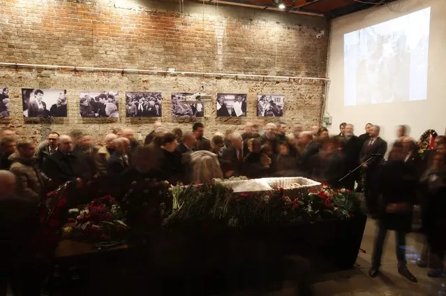 People surround the coffin as they attend a memorial service before the funeral of Boris Nemtsov in Moscow, March 3, 2015. Several hundred Russians, many carrying red carnations, queued on Tuesday to pay their respects to Nemtsov, the Kremlin critic whose murder last week showed the hazards of speaking out against Russian President Vladimir Putin. REUTERS/Maxim Zmeyev 