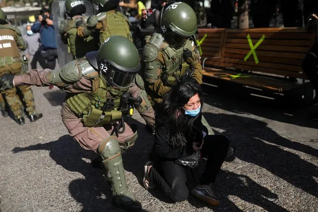 Riot police detain a demonstrator during a rally as constitutional assembly members hold first session to draft a new constitution, in Santiago, Chile on July 4, 2021. (Photo by Pablo Sanhueza/Reuters)