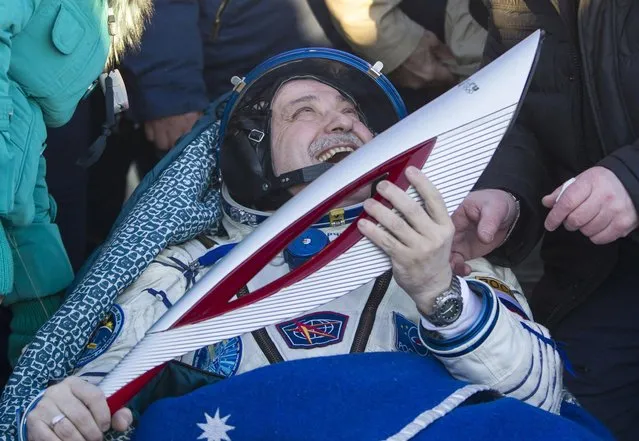 International Space Station (ISS) crew member Russian cosmonaut Fyodor Yurchikhin holds the torch of the 2014 Sochi Winter Olympic Games after Soyuz TMA-09M capsule carrying ISS crew of Yurchikhin, American Karen Nyberg and Luca Parmitano of Italy aboard landed in a remote area near the town of Zhezkazgan in central Kazakhstan Monday, November 11, 2013. The Russian space capsule returned to Earth on Monday from the ISS in a flawless landing on the steppes of Kazakhstan. (Photo by Shamil Zhumatov/AP Photo)