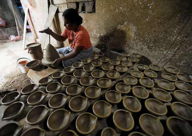 A woman makes clay lamps for Tamil devotees ahead of Diwali or Deepavali festival at a workshop in Biyagama, Sri Lanka October 26, 2016. (Photo by Dinuka Liyanawatte/Reuters)