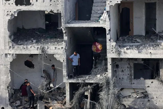 People salvage some belongings from a damaged building following Israeli bombing on Rafah in the southern Gaza Strip, on November 11, 2023, as battles between Israel and the Palestinian Hamas movement continue. (Photo by Said Khatib/AFP Photo)