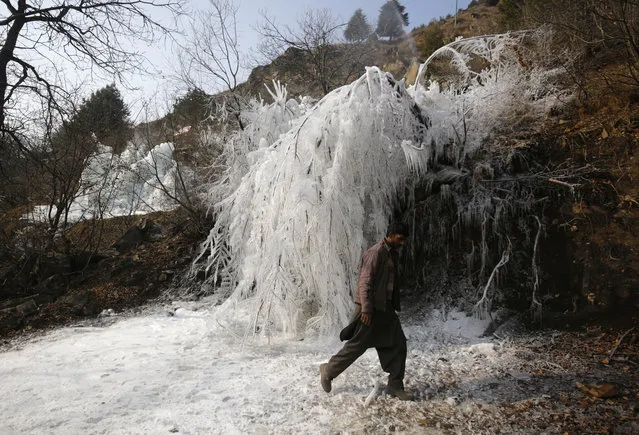A Kashmiri man walks past icicles created by water from a leaking supply pipe in the Tangmarg area of north Kashmir, some 30 kilometres from Srinagar the summer capital of Indian Kashmir, 27 December 2018. Kashmir valley is witnessing record-breaking cold this winter. The night of 27 December was the coldest night in 28 years at minus 7.6 degree Celsius. The local meteorological department has said that the ongoing cold conditions are expected to continue until New Year's Eve. (Photo by Farooq Khan/EPA/EFE)