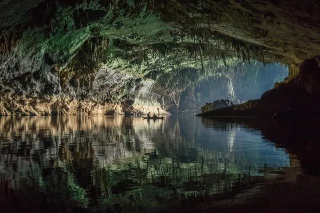 A blue-tinted glow from outside illuminates the entrance chamber of the cave on March 2015 at Tham Khoun Ex, Laos. (Photo by John Spies/Barcroft Media/ABACAPress)