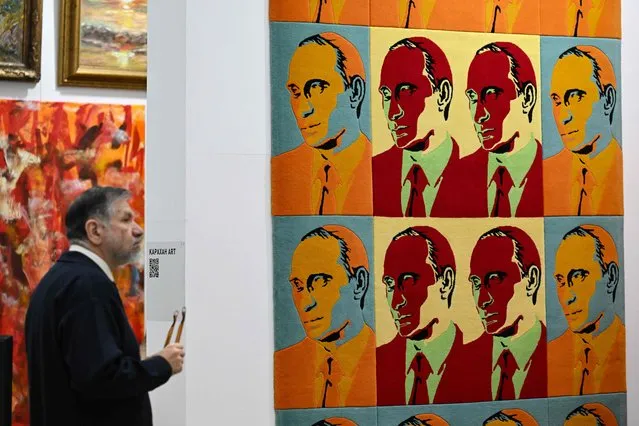 The unique designer carpet depicting Russian President Vladimir Putin in the style of Andy Warhol's iconic portraits made by Russia's designer carpets factory “Imperial-Style” is presented at the annual 49th Russian Antique Salon in Moscow on November 23, 2023. The carpets of the factory, which was founded by Grigory Skvortsov in 1998, decorate the Kremlin halls, state residences, luxury hotels. (Photo by Natalia Kolesnikova/AFP Photo)
