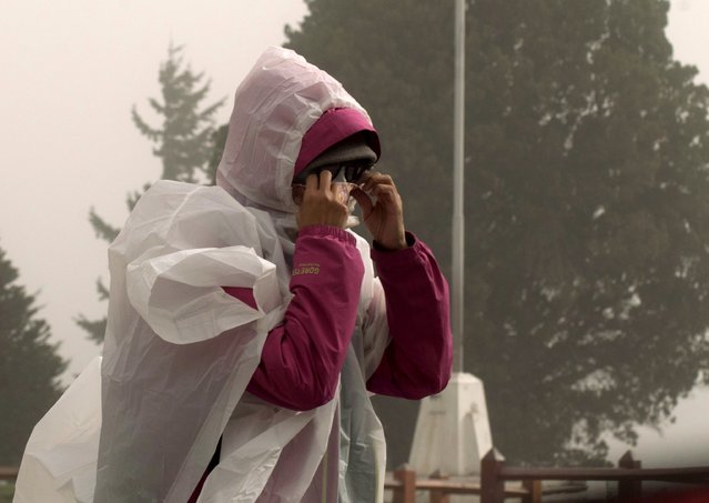 A woman, wearing a surgical mask to protect herself against ash from Calbuco volcano, walks by the Centro Civico (Civic Centre) in the Patagonian Argentine city of San Carlos de Bariloche April 23, 2015. (Photo by Alejandra Bartoliche/Reuters)